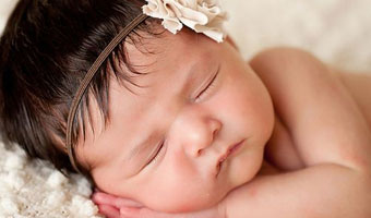 Bébé qui dort avec fleur dans les cheveux